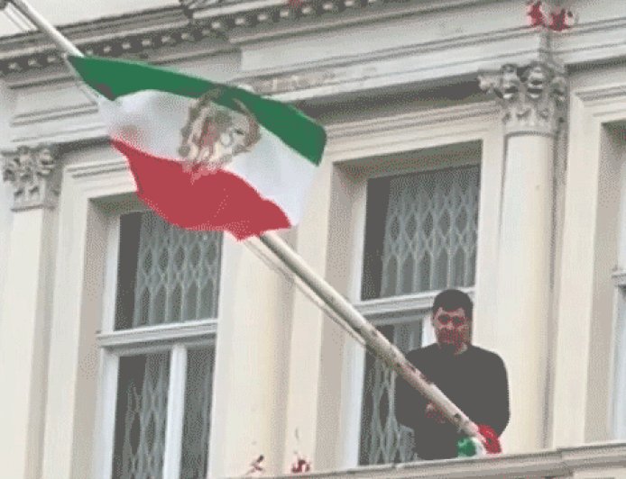 Protester scales Iranian Embassy in London, tears down regime flag, hoists pre-revolution symbol